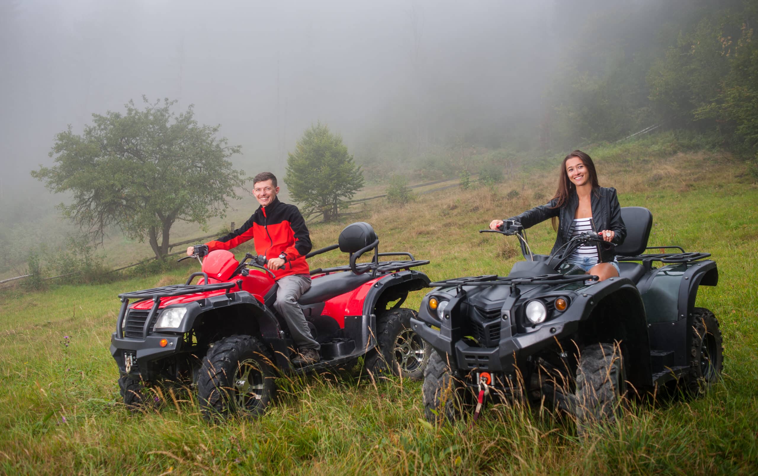 Couple driving four wheeler ATV offroad