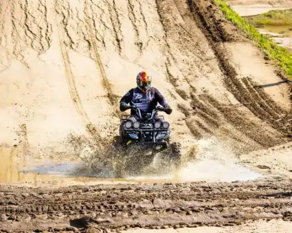 Man Riding Explorer GT Down Hill On Dirt Track In Race Gear
