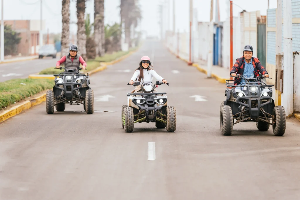 Three people driving quad bikes ina  city