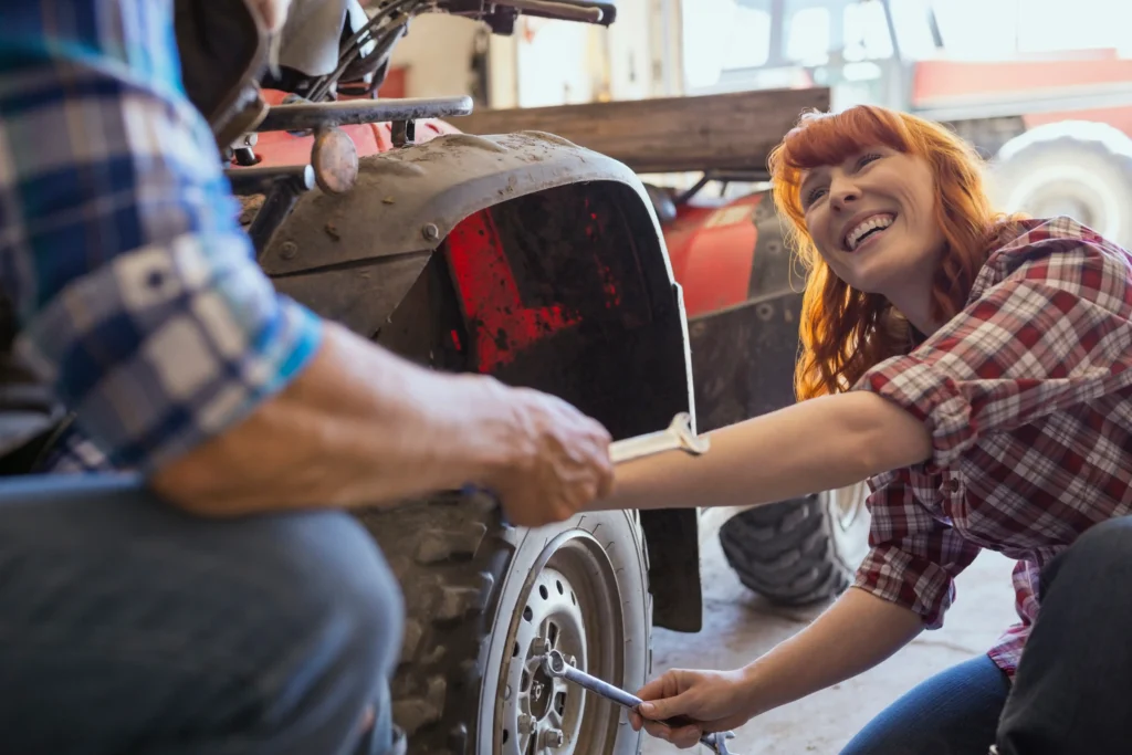 quad bike maintenance being conducted by man and woman in garage